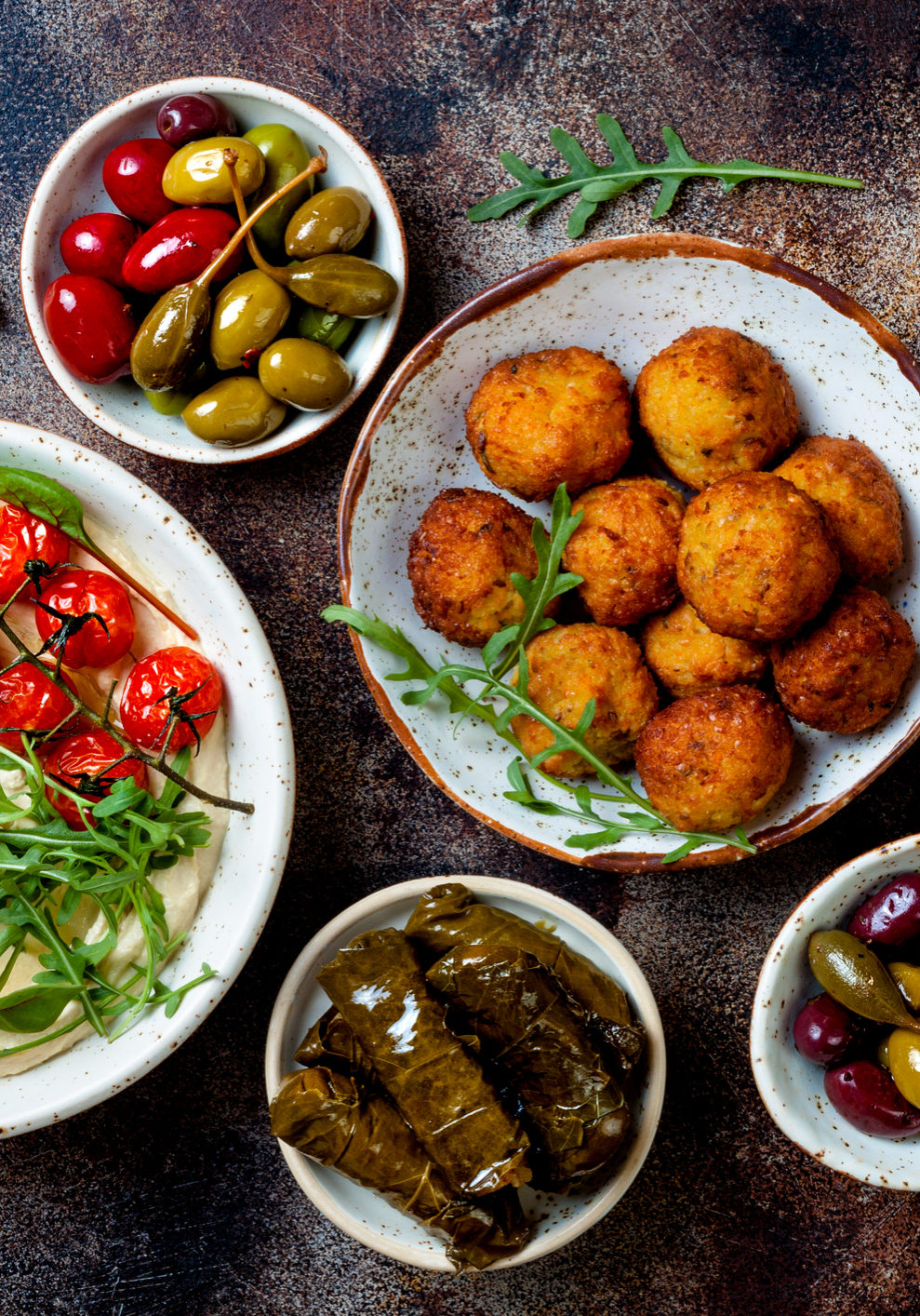 Arabic traditional cuisine. Middle Eastern meze with pita, olives, hummus, stuffed dolma, falafel balls, pickles. Mediterranean appetizer party idea